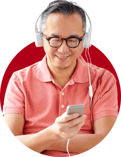 A man wearing headphones and holding a cell phone.