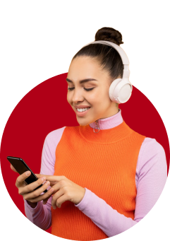 A woman wearing headphones and holding her cell phone.