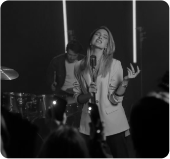 A woman singing into a microphone in front of a crowd.