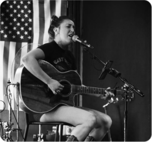 A woman sitting on top of a chair holding a guitar.